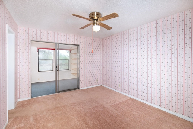 2992 County Road 100, Brady, TX 76825 - unfurnished room featuring a ceiling fan, wallpapered walls, a textured ceiling, carpet flooring, and baseboards
