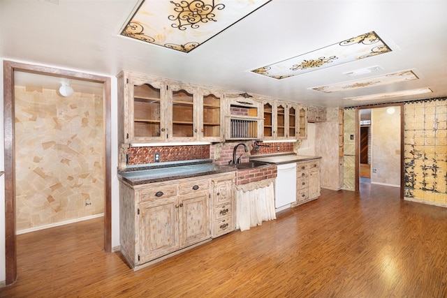 2992 County Road 100, Brady, TX 76825 - kitchen featuring dark countertops, dishwasher, light wood-style flooring, glass insert cabinets, and wallpapered walls
