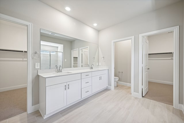 516 Stagg St, Mckinney, TX 75069 - bathroom with double vanity, a walk in closet, toilet, a shower stall, and recessed lighting