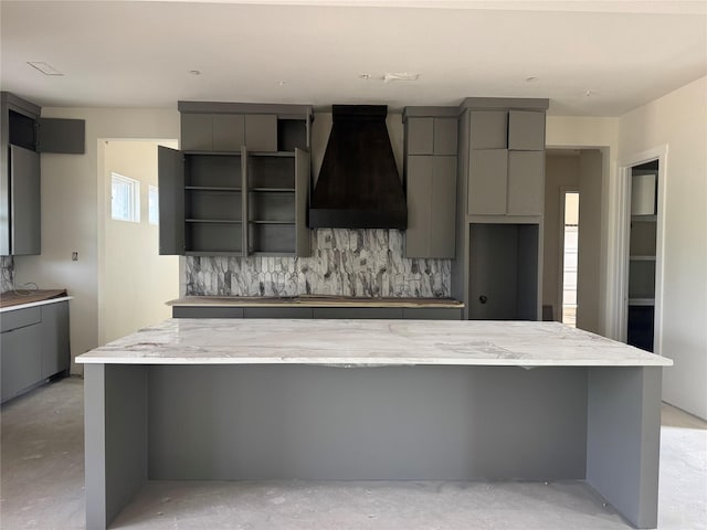 1037 Woodland Rd, Weatherford, TX 76088 - kitchen with gray cabinetry, premium range hood, concrete flooring, and a large island