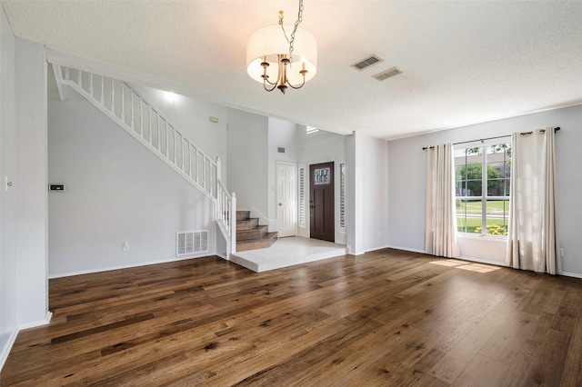 2221 Bennington Ave, Flower Mound, TX 75028 - entrance foyer with stairs, hardwood / wood-style flooring, a chandelier, baseboards, and a textured ceiling