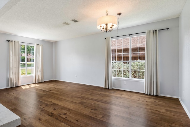 2221 Bennington Ave, Flower Mound, TX 75028 - spare room with a chandelier, wood finished floors, a textured ceiling, and baseboards