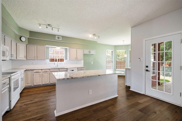 2221 Bennington Ave, Flower Mound, TX 75028 - kitchen featuring white appliances, a center island, dark wood-style flooring, tasteful backsplash, and a textured ceiling