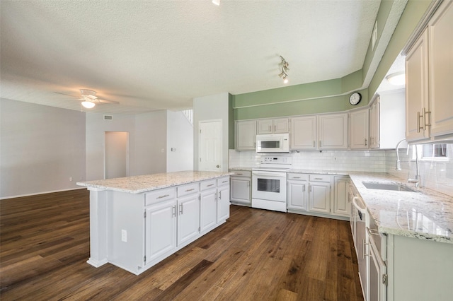 2221 Bennington Ave, Flower Mound, TX 75028 - kitchen featuring white appliances, a sink, a center island, dark wood-type flooring, and a textured ceiling