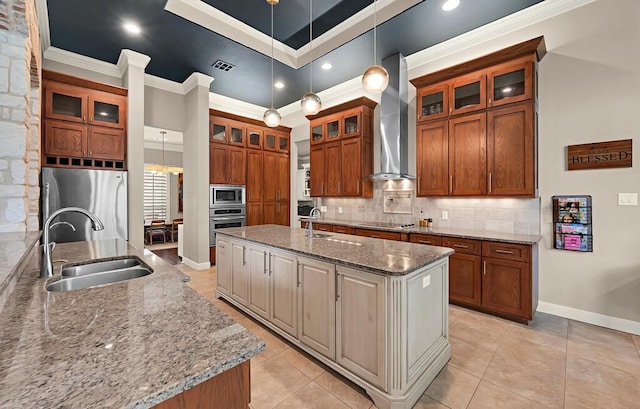 103 Saintsbury Cir, Waco, TX 76712 - kitchen with wall chimney range hood, a sink, appliances with stainless steel finishes, a kitchen island with sink, and brown cabinets