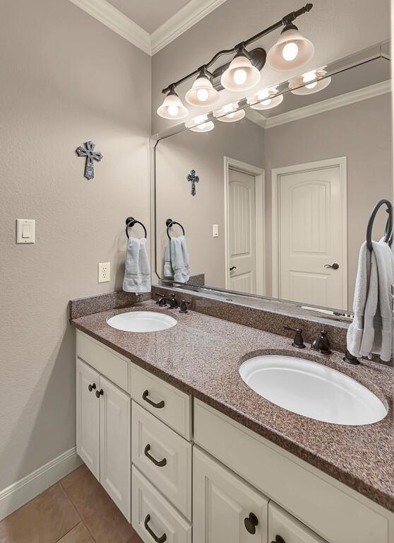 103 Saintsbury Cir, Waco, TX 76712 - full bathroom featuring double vanity, ornamental molding, tile patterned floors, and baseboards