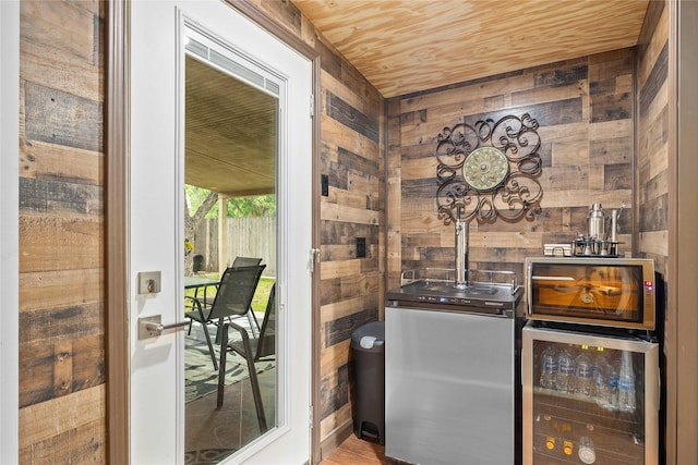 2507 16th St, Brownwood, TX 76801 - bar area featuring wooden walls, beverage cooler, wooden ceiling, and fridge