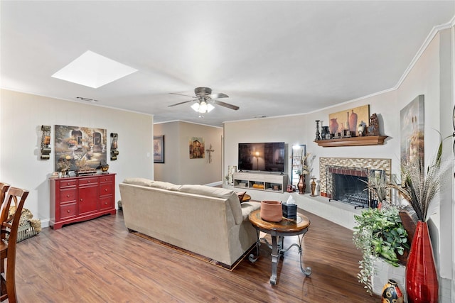 2507 16th St, Brownwood, TX 76801 - living area featuring a skylight, ornamental molding, wood finished floors, ceiling fan, and a fireplace with raised hearth