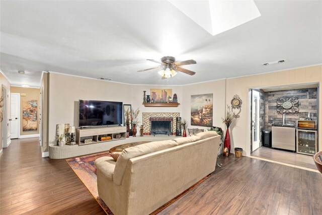 2507 16th St, Brownwood, TX 76801 - living room featuring ornamental molding, beverage cooler, wood finished floors, a fireplace, and ceiling fan