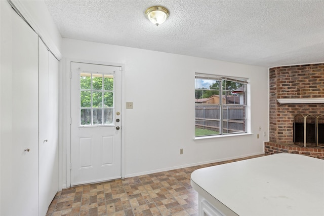 6003 Springwood Dr, Arlington, TX 76001 - bedroom featuring a textured ceiling, a closet, a brick fireplace, and baseboards
