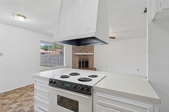 6003 Springwood Dr, Arlington, TX 76001 - kitchen featuring electric range, a textured ceiling, white cabinetry, light countertops, and a brick fireplace