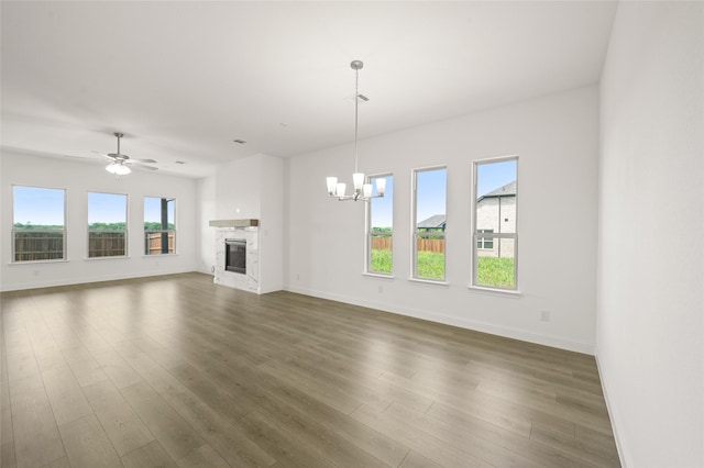 2397 Rams Horn Dr, Waxahachie, TX 75165 - unfurnished living room with a chandelier, dark wood-style floors, baseboards, a glass covered fireplace, and ceiling fan
