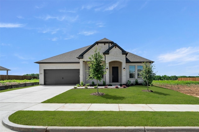 2397 Rams Horn Dr, Waxahachie, TX 75165 - french country inspired facade with an attached garage, brick siding, concrete driveway, and a shingled roof