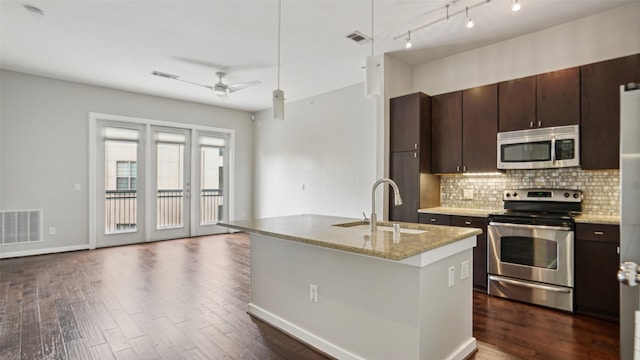 2950 Mckinney Ave Unit 316, Dallas, TX 75204 - kitchen with stainless steel appliances, a sink, decorative backsplash, a ceiling fan, and dark wood-style floors