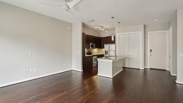 2950 Mckinney Ave Unit 316, Dallas, TX 75204 - kitchen featuring appliances with stainless steel finishes, dark brown cabinets, ceiling fan, decorative backsplash, and light countertops