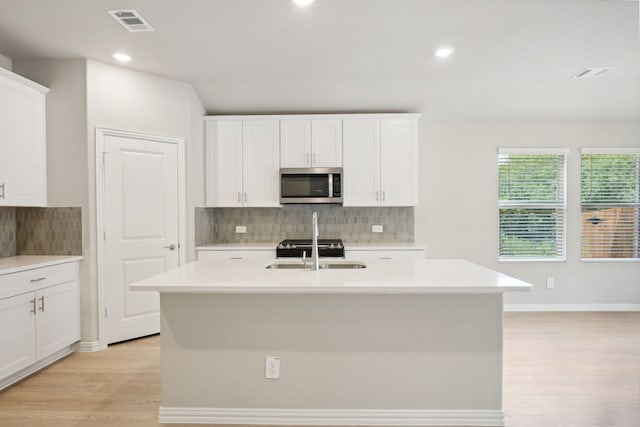 414 Stagg St, Mckinney, TX 75069 - kitchen featuring stainless steel microwave, a sink, light wood-style flooring, backsplash, and light countertops