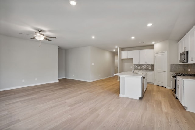 414 Stagg St, Mckinney, TX 75069 - kitchen with range with gas cooktop, stainless steel microwave, a sink, a ceiling fan, and backsplash