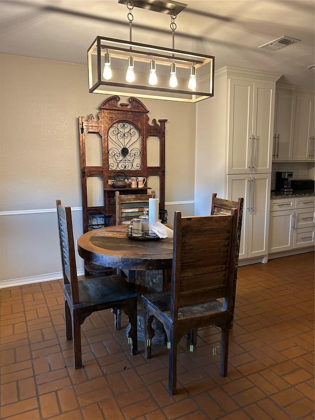 7750 Dentcrest Dr, Dallas, TX 75254 - dining area with brick floors and a wainscoted wall