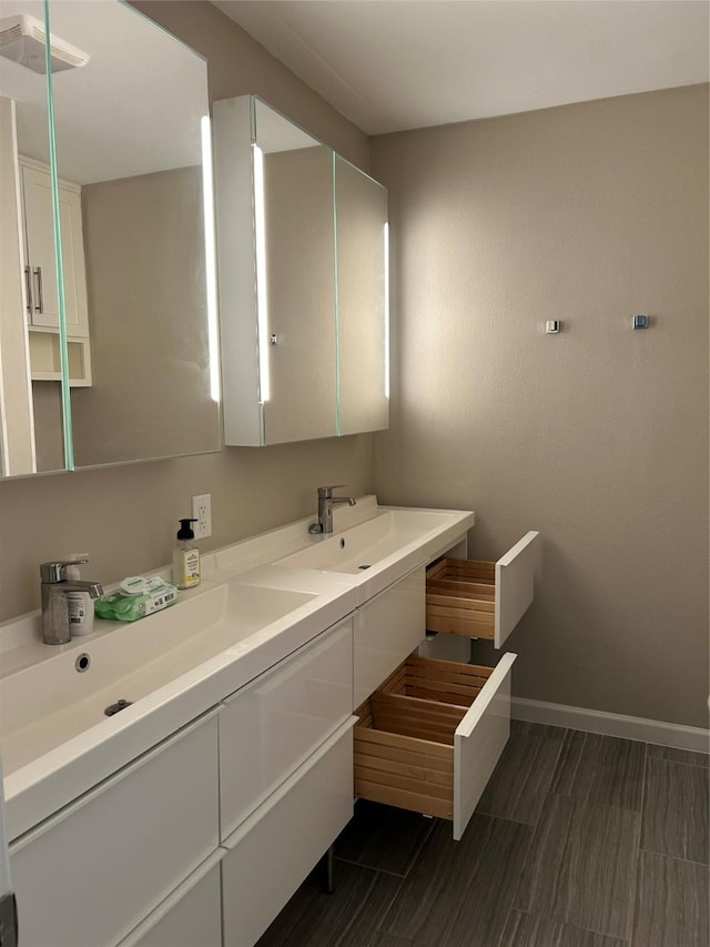 7750 Dentcrest Dr, Dallas, TX 75254 - bathroom featuring double vanity and baseboards