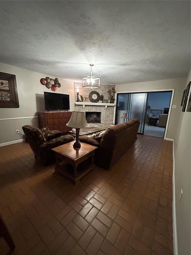 7750 Dentcrest Dr, Dallas, TX 75254 - living room featuring brick patterned flooring, a chandelier, a textured ceiling, a fireplace, and baseboards