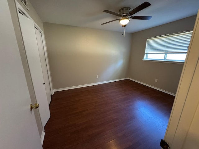 7750 Dentcrest Dr, Dallas, TX 75254 - unfurnished bedroom featuring dark wood finished floors, baseboards, and a ceiling fan