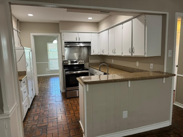7750 Dentcrest Dr, Dallas, TX 75254 - kitchen featuring stainless steel range with electric cooktop, under cabinet range hood, a peninsula, brick floors, and baseboards