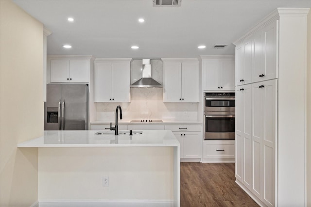 902 Mission Dr, Southlake, TX 76092 - kitchen featuring stainless steel appliances, wall chimney range hood, a sink, white cabinets, and recessed lighting