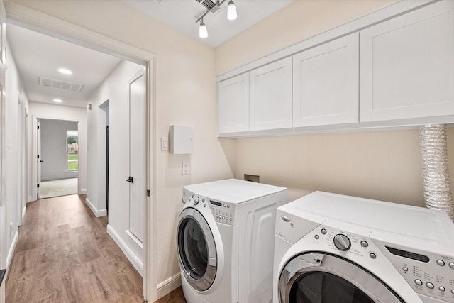 902 Mission Dr, Southlake, TX 76092 - washroom with washer and dryer, light wood-style flooring, cabinet space, and baseboards