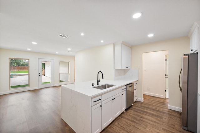 902 Mission Dr, Southlake, TX 76092 - kitchen featuring a sink, appliances with stainless steel finishes, wood finished floors, light countertops, and white cabinets