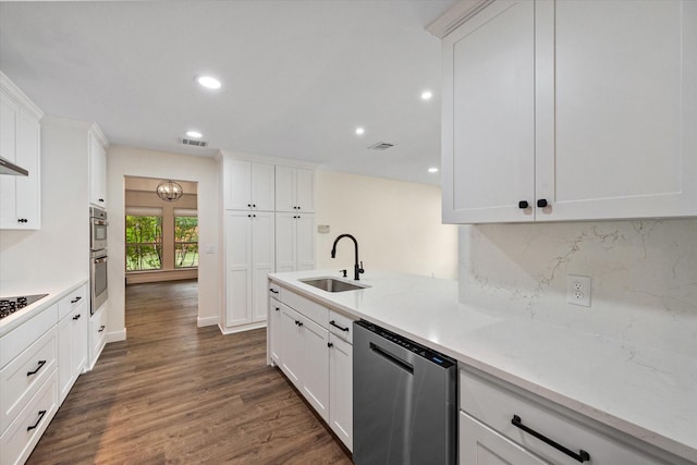 902 Mission Dr, Southlake, TX 76092 - kitchen with a sink, stainless steel appliances, dark wood-style flooring, backsplash, and white cabinets