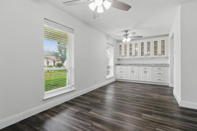 1025 Briar Way, Garland, TX 75043 - spare room featuring a ceiling fan, baseboards, and dark wood-style floors