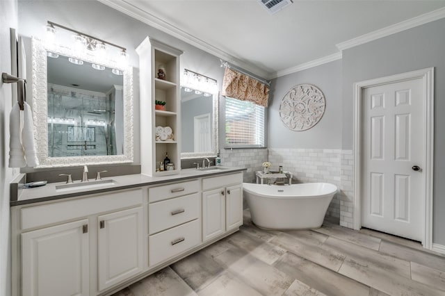 2362 Barret Dr, Frisco, TX 75033 - bathroom with crown molding, a stall shower, double vanity, a freestanding tub, and tile walls