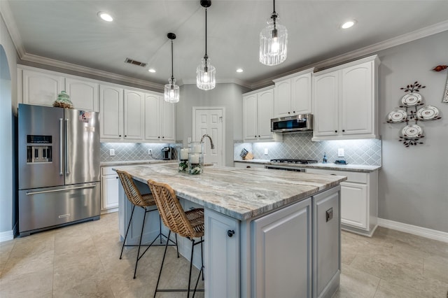 2362 Barret Dr, Frisco, TX 75033 - kitchen featuring appliances with stainless steel finishes, decorative backsplash, white cabinetry, light stone counters, and a kitchen island with sink