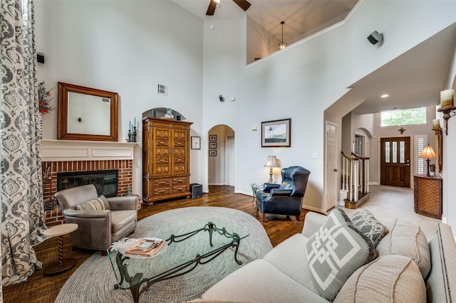 2362 Barret Dr, Frisco, TX 75033 - living area with a towering ceiling, arched walkways, a ceiling fan, a fireplace, and baseboards