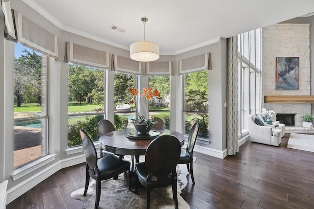 702 Malton Ln, Southlake, TX 76092 - dining area featuring crown molding, dark wood-style flooring, a fireplace, and baseboards