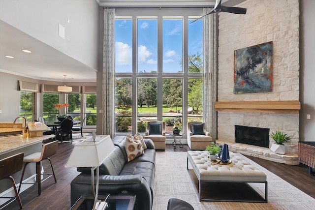 702 Malton Ln, Southlake, TX 76092 - living room with a fireplace, a towering ceiling, dark wood-type flooring, crown molding, and recessed lighting