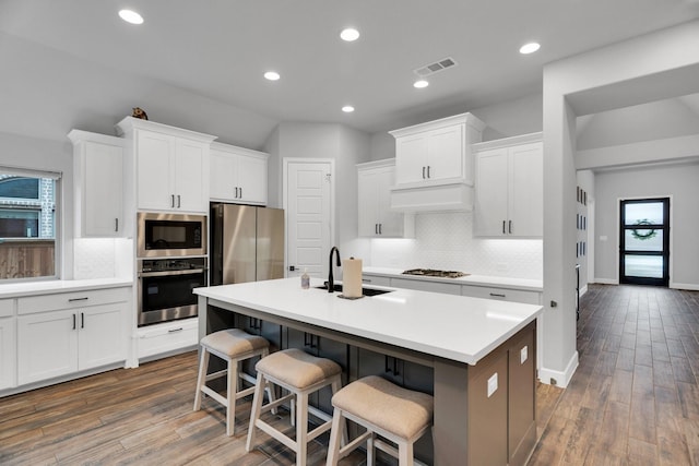 1210 Old Rocksprings Pass, Mansfield, TX 76063 - kitchen with appliances with stainless steel finishes, a sink, tasteful backsplash, a breakfast bar area, and white cabinetry
