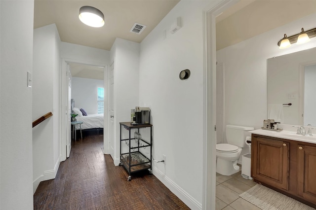 832 Lake Worth Trl, Little Elm, TX 75068 - bathroom featuring toilet, vanity, connected bathroom, wood finished floors, and baseboards