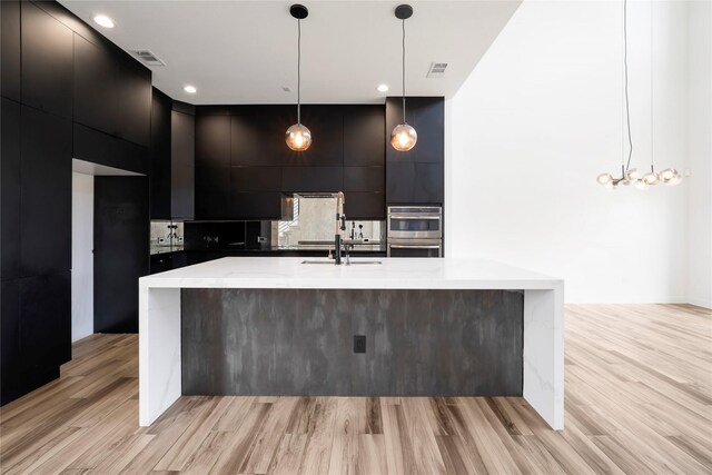 8356 Fairview Dr, Frisco, TX 75033 - kitchen featuring modern cabinets, stainless steel double oven, light wood-style flooring, a sink, and a large island