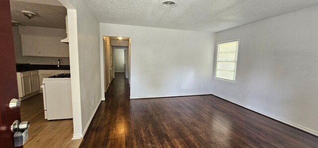 5170 Cardiff St, Dallas, TX 75241 - spare room with dark wood finished floors, a textured ceiling, and baseboards