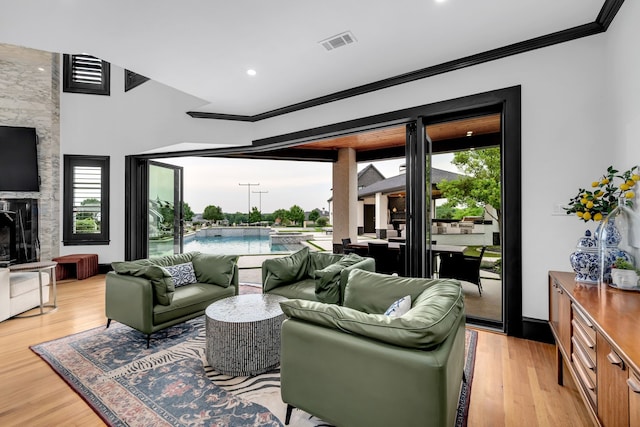 2600 Lakeview Ct, Prosper, TX 75078 - living area with light wood-style flooring, crown molding, and a stone fireplace