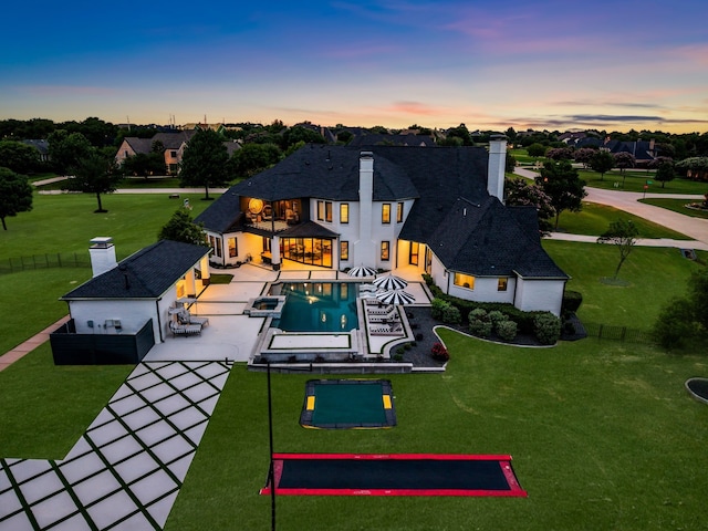 2600 Lakeview Ct, Prosper, TX 75078 - back of property at dusk with a patio, a chimney, and an outdoor pool