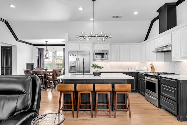 2600 Lakeview Ct, Prosper, TX 75078 - kitchen featuring appliances with stainless steel finishes, a chandelier, under cabinet range hood, white cabinets, and recessed lighting