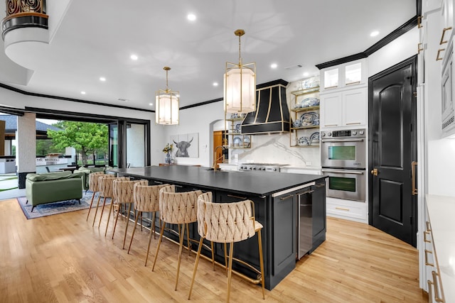 2600 Lakeview Ct, Prosper, TX 75078 - kitchen featuring stainless steel double oven, open shelves, custom range hood, decorative backsplash, and a kitchen island with sink