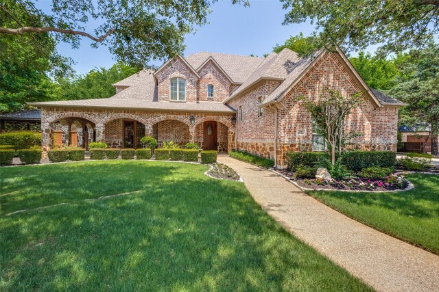 3704 Imperial Dr, Flower Mound, TX 75028 - french provincial home featuring stone siding, a front yard, brick siding, and a shingled roof