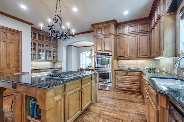 3704 Imperial Dr, Flower Mound, TX 75028 - kitchen with a sink, appliances with stainless steel finishes, arched walkways, a chandelier, and crown molding
