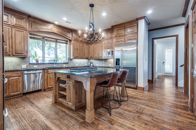 3704 Imperial Dr, Flower Mound, TX 75028 - kitchen with built in appliances, a sink, a kitchen island, a kitchen breakfast bar, and a chandelier