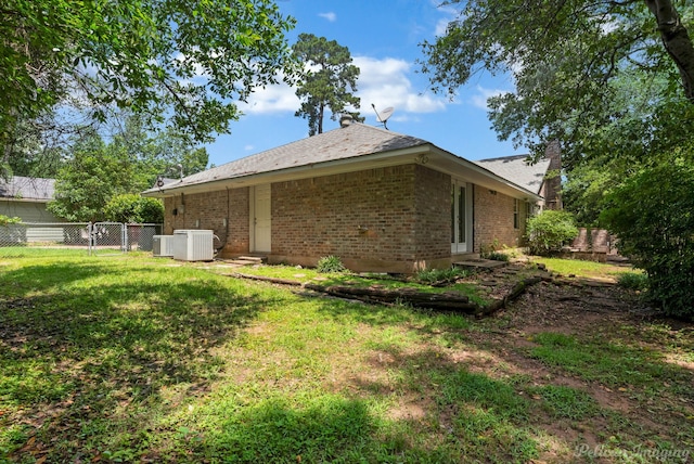 605 Erie St, Shreveport, LA 71106 - rear view of house with brick siding, central AC unit, and a gate