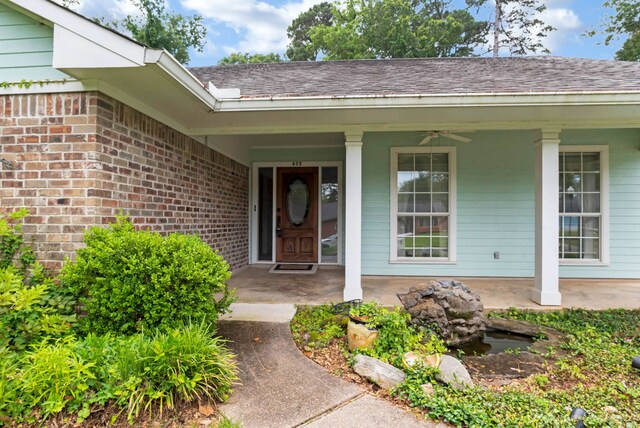 605 Erie St, Shreveport, LA 71106 - doorway to property featuring a porch, brick siding, roof with shingles, and ceiling fan
