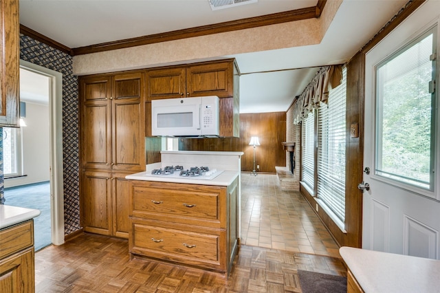 1122 Gloucester Ct N, Irving, TX 75062 - kitchen with white appliances, light countertops, brown cabinets, crown molding, and wallpapered walls